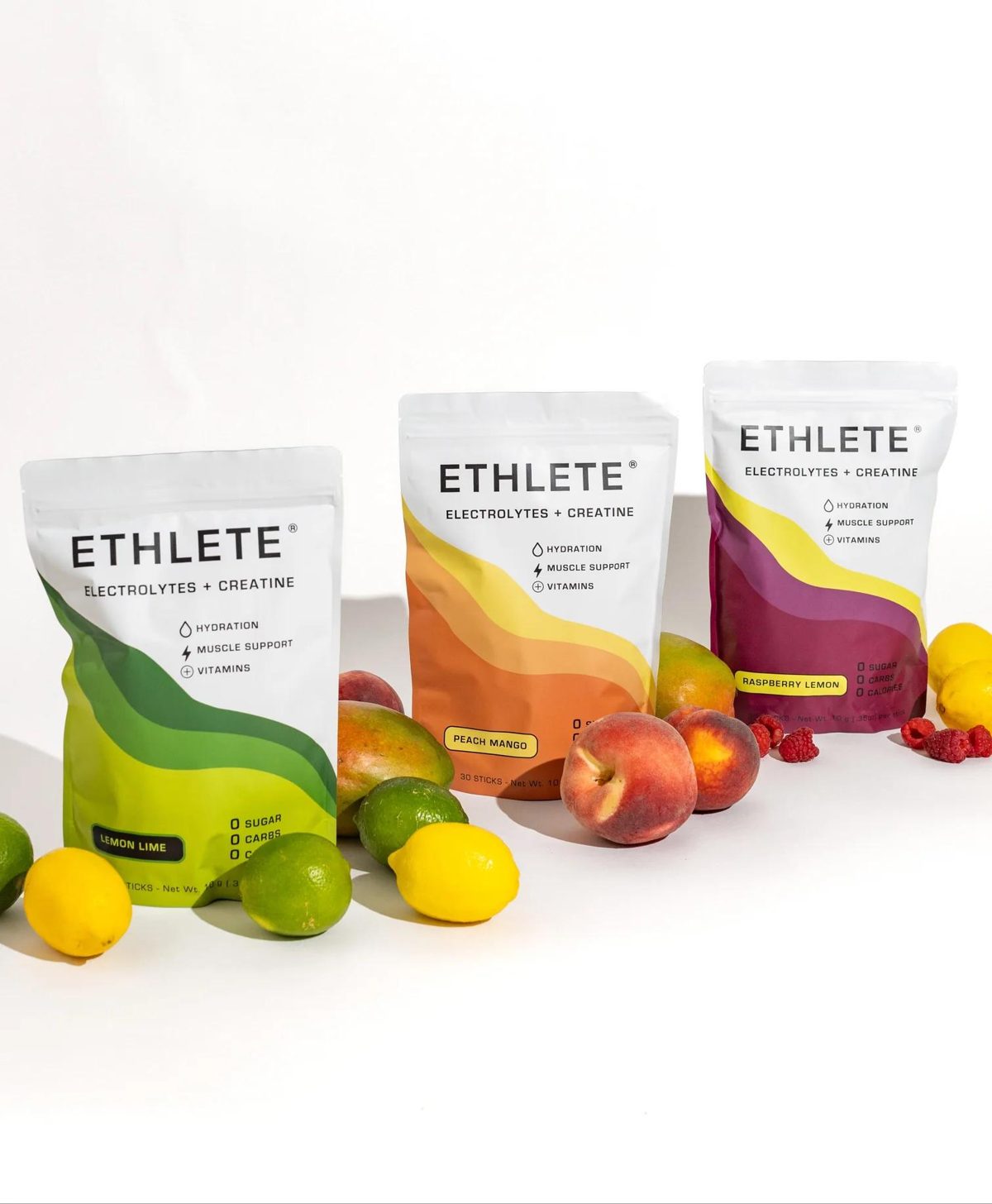 ETHLETE Electrolytes + Creatine bags with fresh lemons, limes, peaches and raspberries