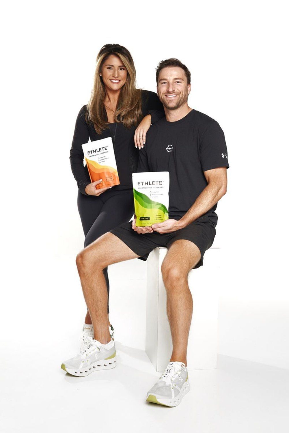 Shelbi and Geoff, the husband-and-wife founders of ETHLETE, holding Peach Mango and Lemon Lime pouches